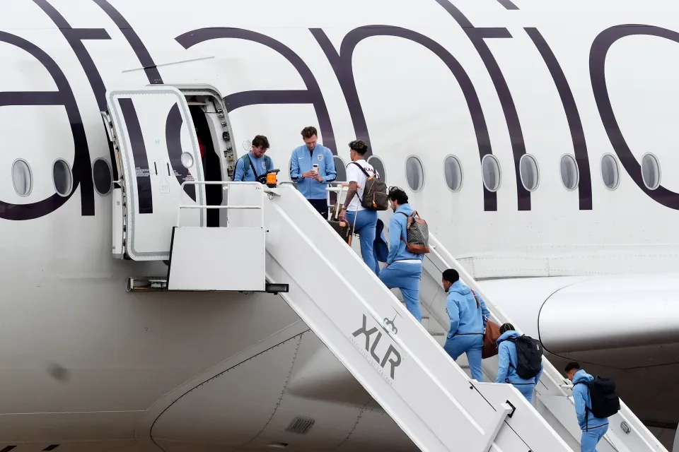 England players arriving in Florida wearing matching blue travel kits